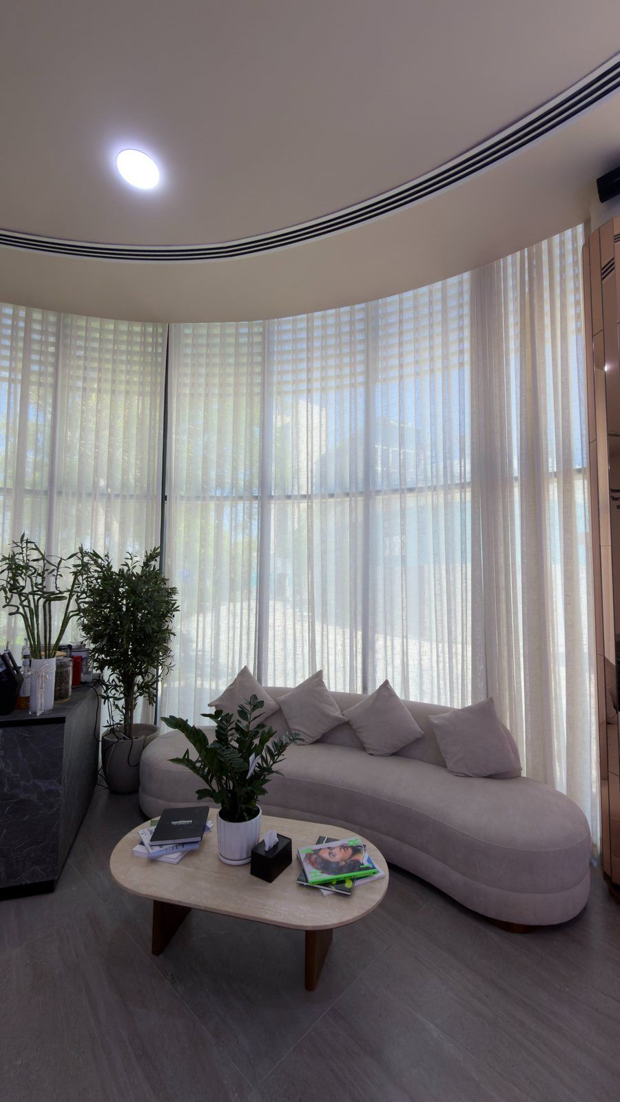Curved sofa and sheer curtains in the lounge of Haitham Labban Beauty Salon, Manama